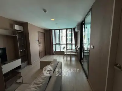 Modern living room with large windows and stylish furniture in a high-rise apartment.