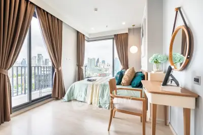 Modern bedroom with city view, large windows, and elegant decor in a high-rise apartment.