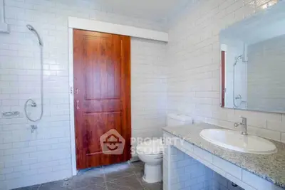 Modern bathroom with white subway tiles and wooden door