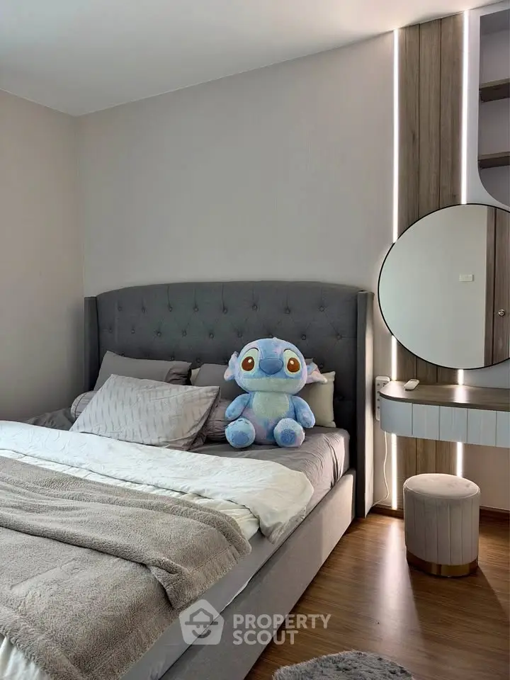 Cozy bedroom with plush toy, modern decor, and stylish lighting