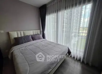 Modern bedroom with large windows and elegant curtains in a high-rise apartment.