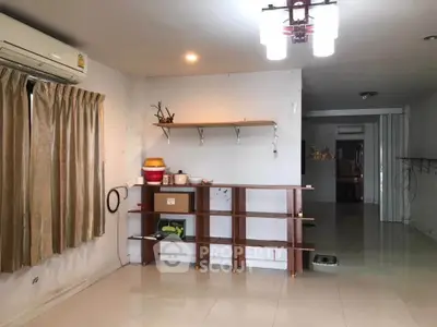 Spacious living room with modern shelving and air conditioning, ideal for comfortable living.