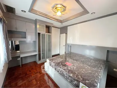 Spacious bedroom with elegant wooden flooring and built-in wardrobe