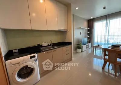 Modern kitchen with washing machine and open layout in stylish apartment