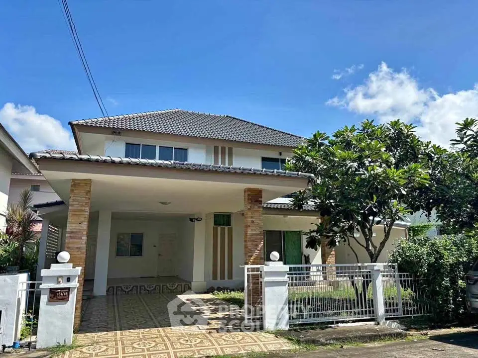Charming two-story house with tiled roof and lush garden in a serene neighborhood.
