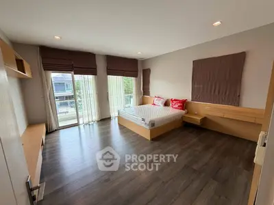 Spacious bedroom with modern design and large windows offering natural light