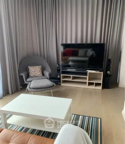 Modern living room with stylish furniture and large TV, perfect for relaxation and entertainment.