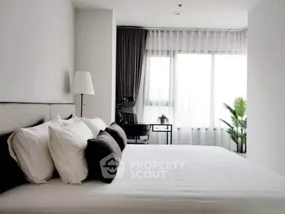 Modern bedroom with large window, stylish decor, and natural light.