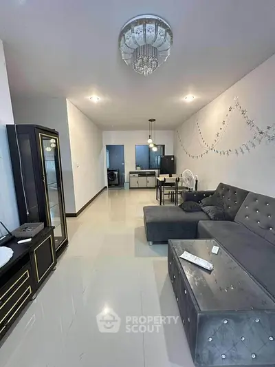 Spacious modern living room with elegant decor and open layout, featuring plush seating and stylish lighting.
