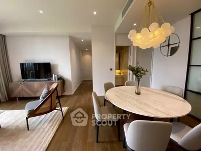Modern living room with elegant dining area and stylish lighting fixture.