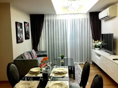 Elegant living room with modern decor, large window, and stylish dining area in a contemporary apartment.