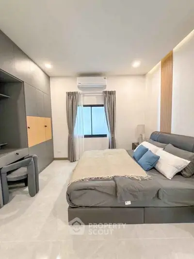 Modern bedroom with sleek design, featuring a large bed, built-in wardrobe, and air conditioning.