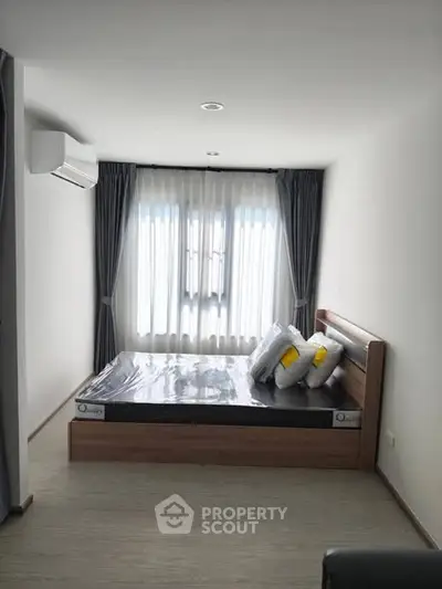 Modern bedroom with sleek design and natural light, featuring a comfortable bed and stylish curtains.