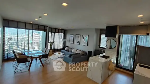 Spacious modern living room with city view and open kitchen layout.