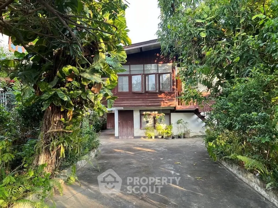 Charming wooden house with lush garden and spacious driveway, perfect for serene living.