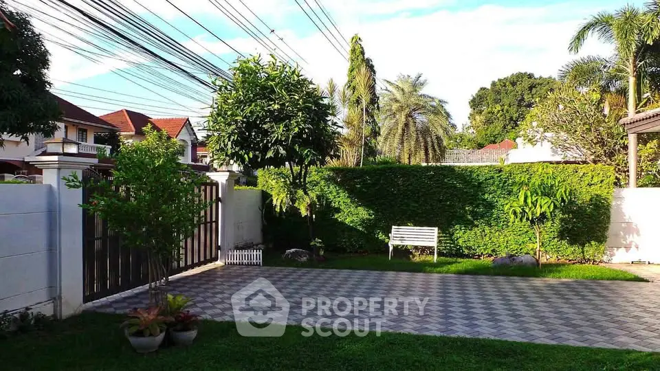Charming garden view with lush greenery and spacious paved area in a serene residential neighborhood.
