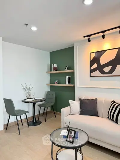 Modern living room with stylish decor, featuring a cozy sofa, chic artwork, and a small dining area.