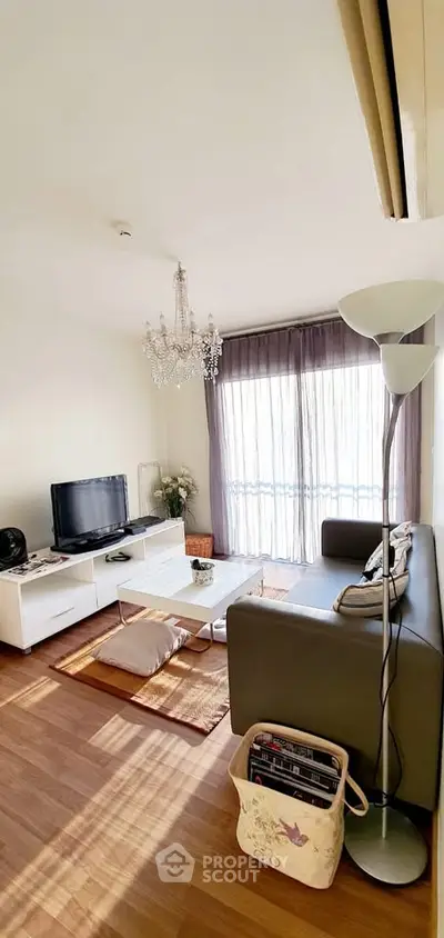Charming living room with elegant chandelier and cozy seating area, perfect for relaxation.