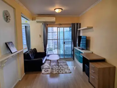 Charming living room with city view, cozy seating, and modern entertainment setup in urban apartment.