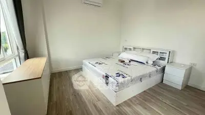 Spacious bedroom with modern furnishings and large window for natural light.