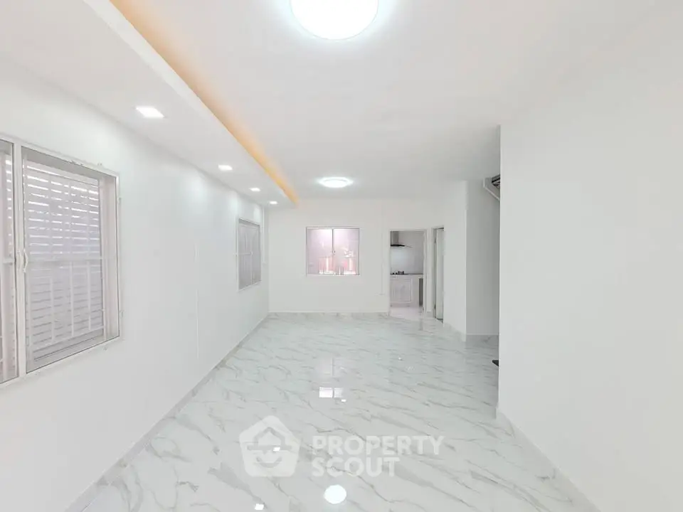 Spacious modern living room with marble flooring and recessed lighting