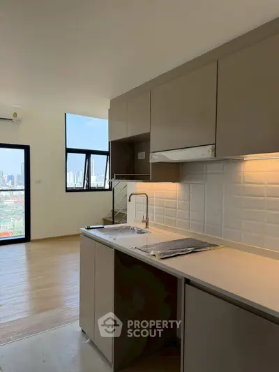 Modern kitchen with sleek cabinetry and city view from window