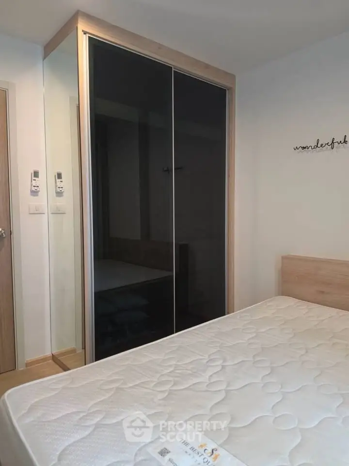 Modern bedroom with sleek wardrobe and comfortable mattress in stylish apartment.