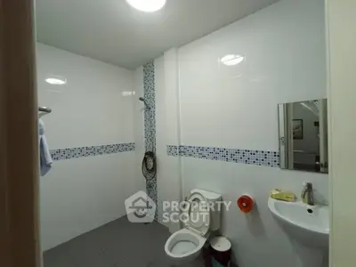 Spacious bathroom with modern fixtures and tiled walls in a real estate property.