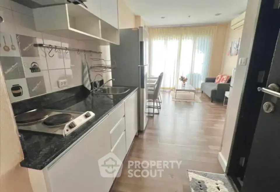 Modern open-layout kitchen with sleek appliances and cozy living area.