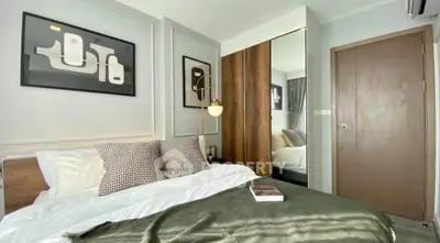 Modern bedroom with stylish decor and cozy ambiance, featuring elegant artwork and ample natural light.