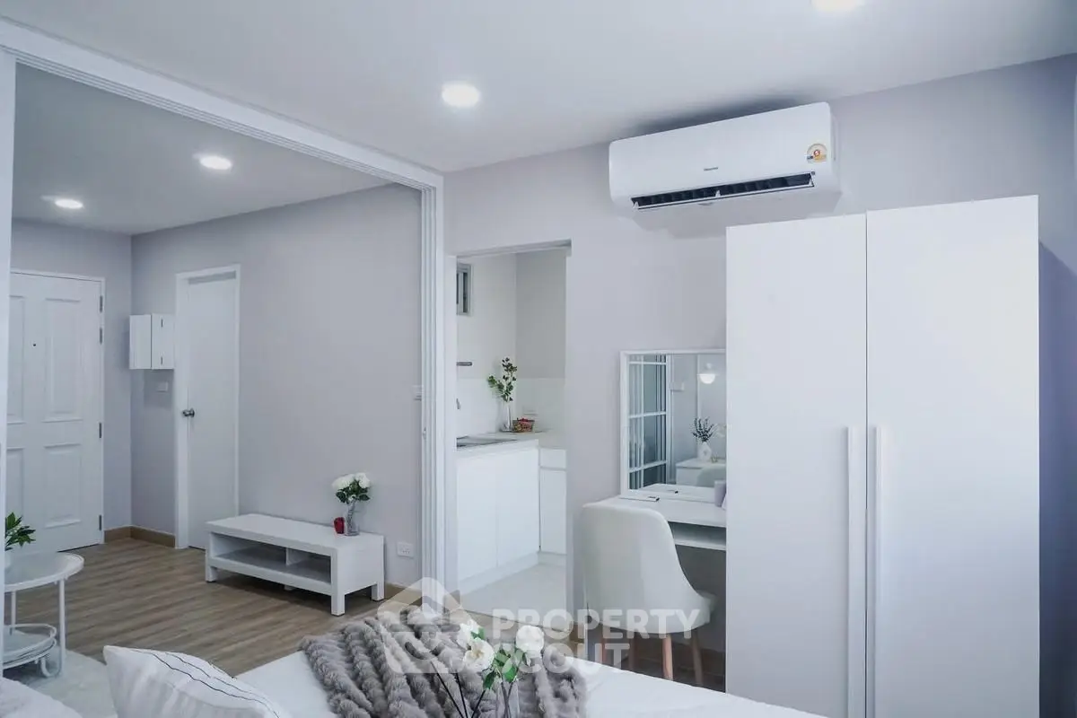 Modern studio apartment with sleek design and air conditioning, featuring a cozy living area and compact kitchen.