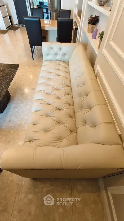 Luxurious living room with elegant cream leather sofa and marble flooring, perfect for modern comfort and style.