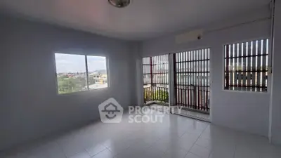 Spacious empty room with large windows and balcony view, perfect for customization.