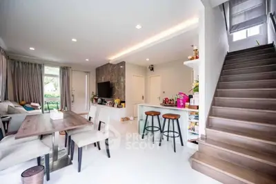 Spacious modern living room with open kitchen and elegant staircase