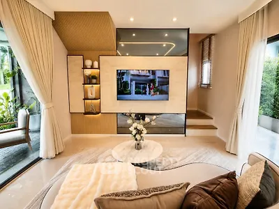 Luxurious living room with modern decor and large windows offering garden views.