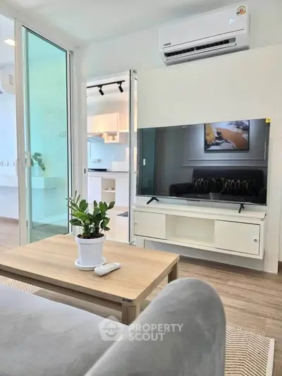 Modern living room with sleek furniture and large TV, featuring a cozy ambiance and stylish decor.