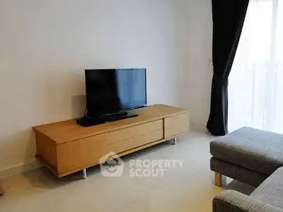 Modern living room with sleek TV stand and large window for natural light.