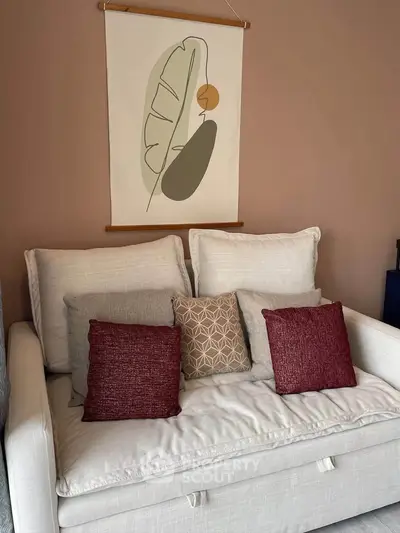Cozy living room with stylish sofa and decorative cushions, perfect for relaxation and modern living.