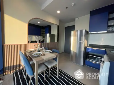 Modern kitchen with dining area, sleek blue cabinets, and stainless steel appliances