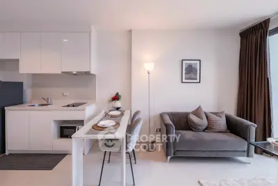 Modern open-layout kitchen and living room with stylish decor and natural light.