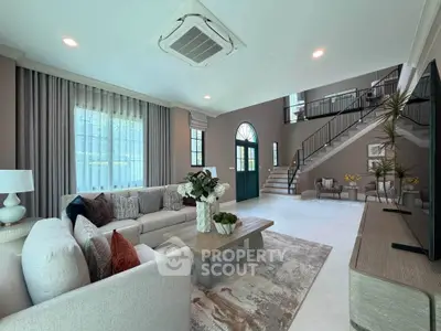 Luxurious living room with elegant decor and spacious layout, featuring a stylish staircase and modern furnishings.