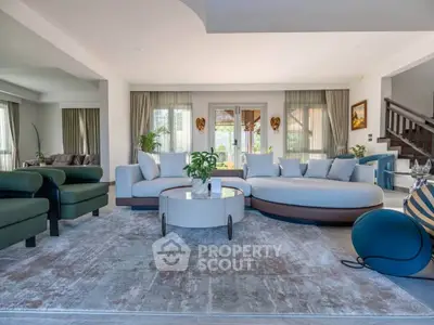 Spacious modern living room with elegant furniture and large windows offering natural light.