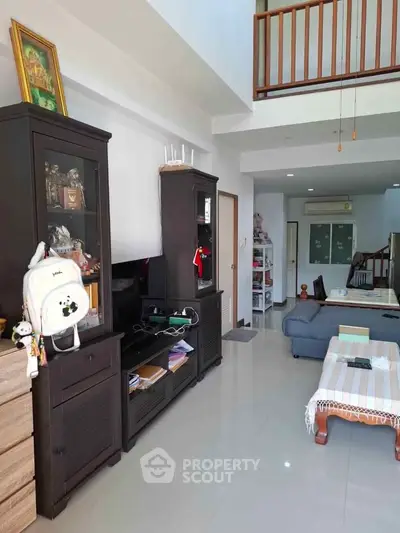 Spacious living room with modern furniture and high ceiling, perfect for family gatherings.
