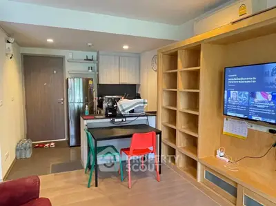 Modern apartment interior with open kitchen and living area, featuring colorful chairs and built-in shelving.