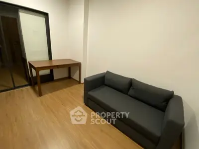 Modern living room with sleek gray sofa and wooden table on polished floor