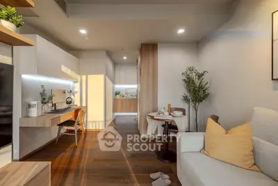 Modern living room with cozy seating and stylish decor, featuring a sleek open kitchen layout.