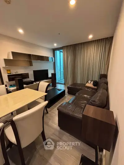 Spacious modern living room with elegant furniture and large windows offering natural light.