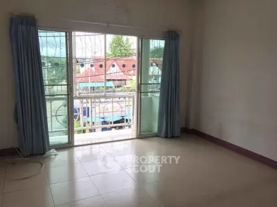 Spacious empty room with large window and balcony view, perfect for customization.