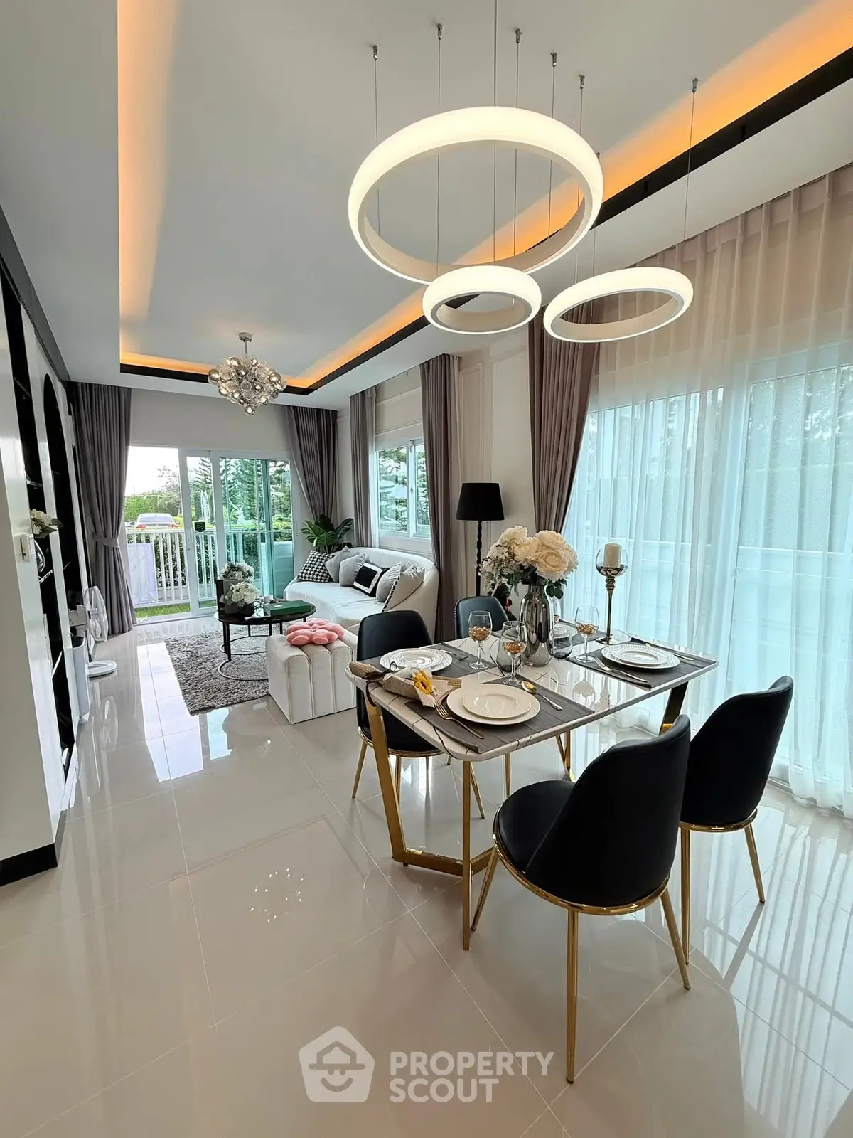 Luxurious open-plan living and dining area with modern decor and elegant lighting.