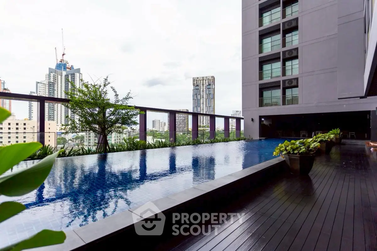 Luxurious high-rise building with stunning rooftop pool and city view.